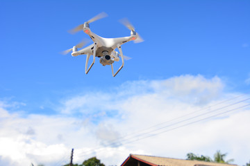 Drone camera flying for take a picture on blue sky background