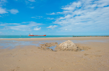 Boat sailing along a beach in sunlight in summer
