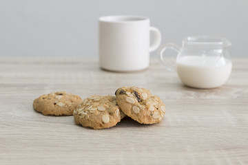 COOKIES AND COFFEE MUG
Oat meal raisin cookies and coffee with milk on the wood table. 