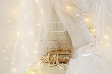 Beautiful white wedding dress and veil on chair with gold garland lights