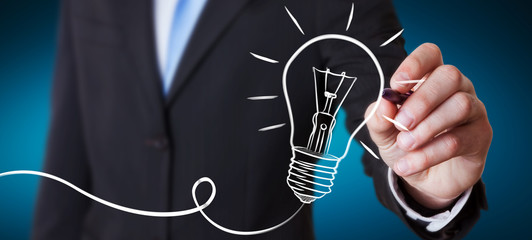 Businessman drawing a sketch lightbulb with a pen