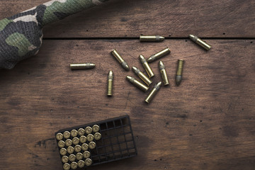 Small caliber 22 long rifle with an optical sight and cartridges in camouflage tape