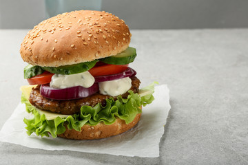 Large burger with vegetables and sauce
