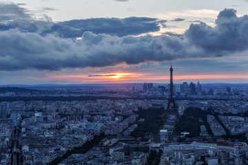 Scenic aerial view of Paris, France, from the Tour Montparnasse with the Eiffel Tower in the background at sunset. Colourful nighttime skyline. Travel background.