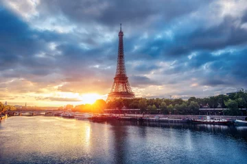 Gordijnen The Eiffel Tower at sunrise. Paris, France. Beautiful skyline of with rising sun and dramatic clouds. © Funny Studio