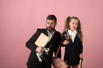 Kid and tutor hold microscope, book and stationery