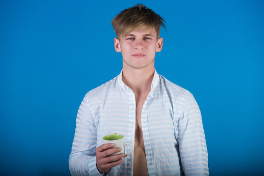 Macho with blond hair holding cup in open shirt