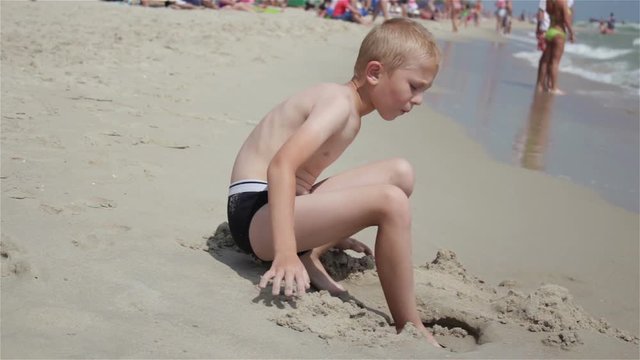 vacation at sea boy/The boy sits on the sand at sea