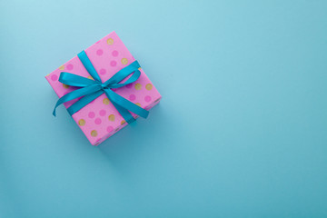 Craft paper pink gift box with as a present for Christmas, new year, valentine day or anniversary on blue background, top view, mock up