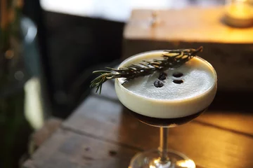 Cercles muraux Cocktail Coffee cocktail with coffee bean and rosemary on top with wood background