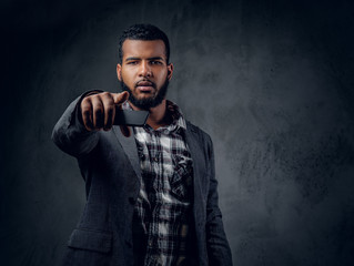 Black hipster male dressed in a fleece shirt and a jacket.