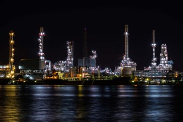 Fototapeta na wymiar Oil refinery plant near river at twilight, Business and Industry concept