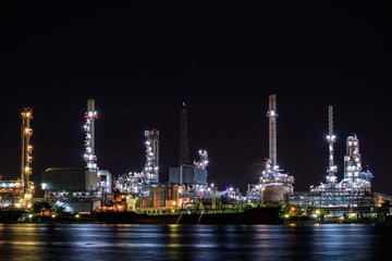 Fototapeta na wymiar Oil refinery plant near river at twilight, Business and Industry concept