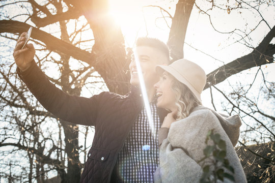 Young couple making self-picture. Happy couple having fun in the park.