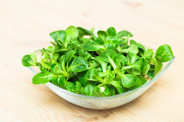 Fresh green salad on a old wooden table.