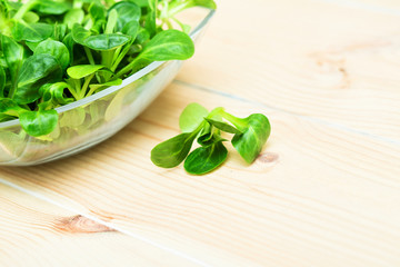 Fresh green salad with spinach on a old wooden table.