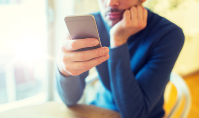 close up of man with smartphones at cafe