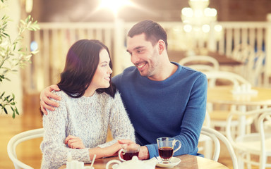 happy couple drinking tea at restaurant