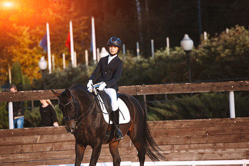 Young jockey brave girl rides on a horse show jumping. Rider on the horse sports competitions
