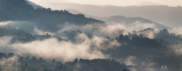 Mountain landscape after storm. Clouds of fog. Misty village