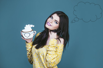 Model woman young and beautiful in the style of pop art on a blue background with a cartoon Cup of hot drink tea or coffee