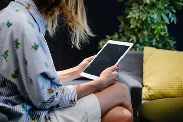 Business person using holding digital tablet mobile pc device over blurred background. Close up technology concept