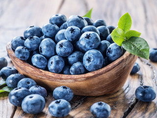 Blueberries in the wooden bowl on the table.