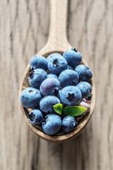 Blueberries in the wooden spoon on the table.