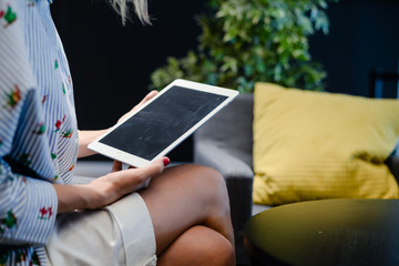 Business person using holding digital tablet mobile pc device over blurred background. Close up technology concept