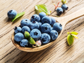 Blueberries in the wooden spoon on the table.