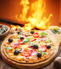 Pizza. Wood-fired oven on the background.