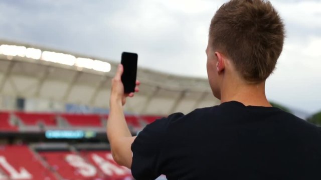 Young Man Takes A Panorama Photo Of Professional Stadium