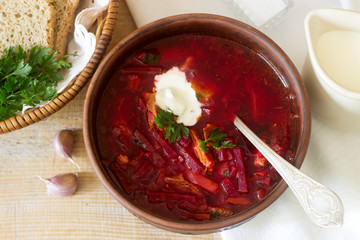 A traditional dish of Russian and Ukrainian cuisine - borsch. Soup with beets, meat, potatoes and beans. Served with sour cream and garlic.