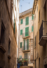 Fototapeta na wymiar Green Shutters Beyond Narrow Mallorca Alley