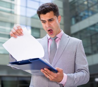 Shocked businessman reading papers