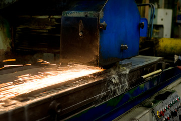 Work of an industrial surface grinding machine. Grinding of a flat metal part.