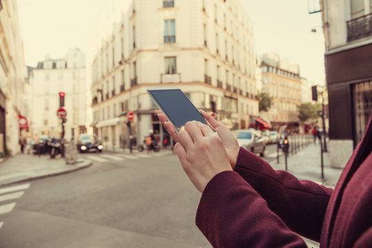Girl holding cellphone in urban surroundings - shallow depth of field.
