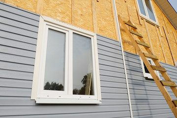 siding covering the wall of a house under construction - obrazy, fototapety, plakaty