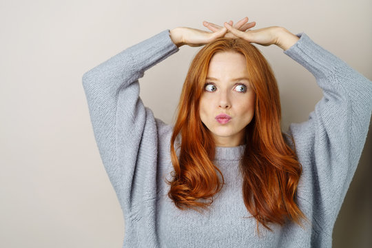 frau mit grauem strickpullover schaut nachdenklich zur seite
