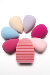 Set of beauty blenders and rubber cleaner on a white background