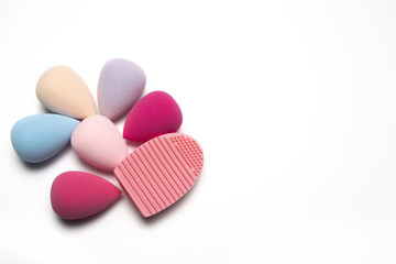 Kit of makeup sponges and rubber cleaner over a white background