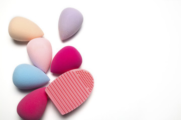 Set of makeup sponges and rubber cleaner on a white background