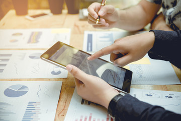 hand of businessman pointing on screen of tablet. There is partner worker beside him.