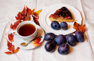 Plum cake and cup of tea on table