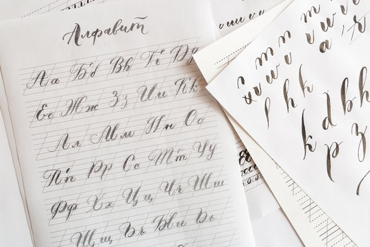 fine-art, education, technique concept. russian alphabeth written on the creamy lined paper with arrows indicating right way to inscribe letters full of harmony and creative fire