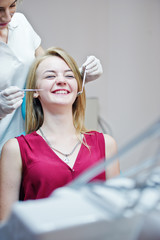Gorgeous young female dentist checking her patient's teeth up in a specially-equipped cabinet.