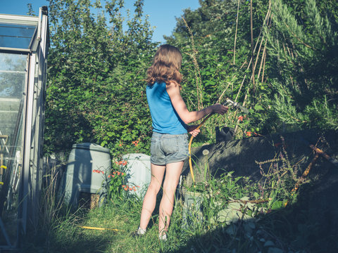 Young woman watering her garden