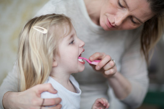 mother brushing her daughter's teeth. dental care, hygiene, toothbrush, mother and child.