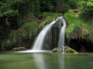 Twin waterfall into green lake