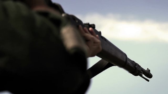 World War Two - German Soldier raises rifle off camera 
